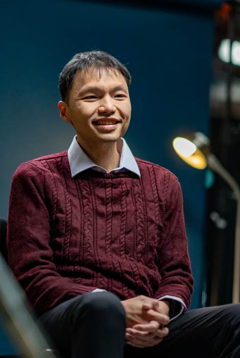 Dr Eric Hadinata seated and smiling in a professional portrait